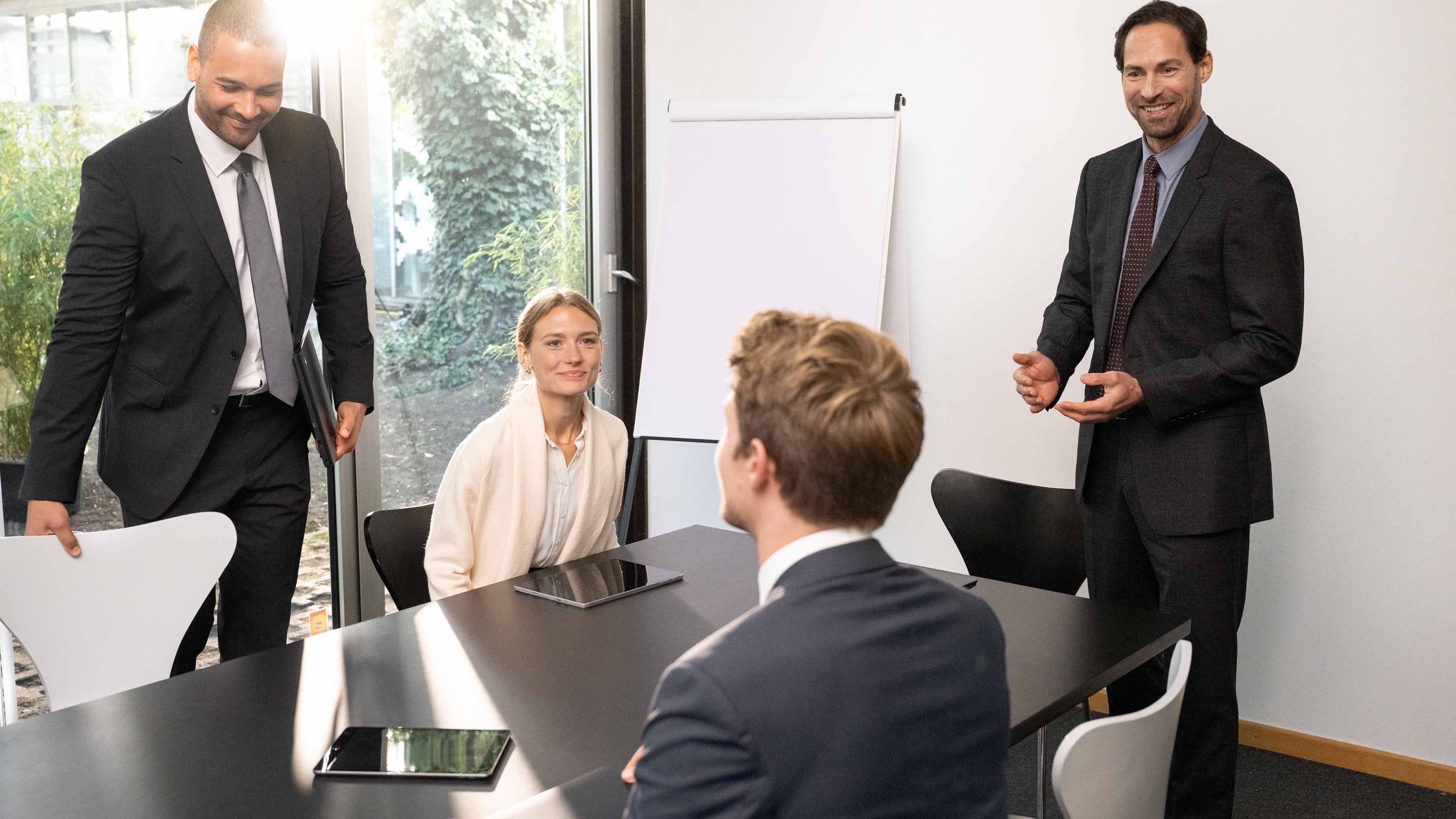 Vier Personen in einem Besprechungsraum.
