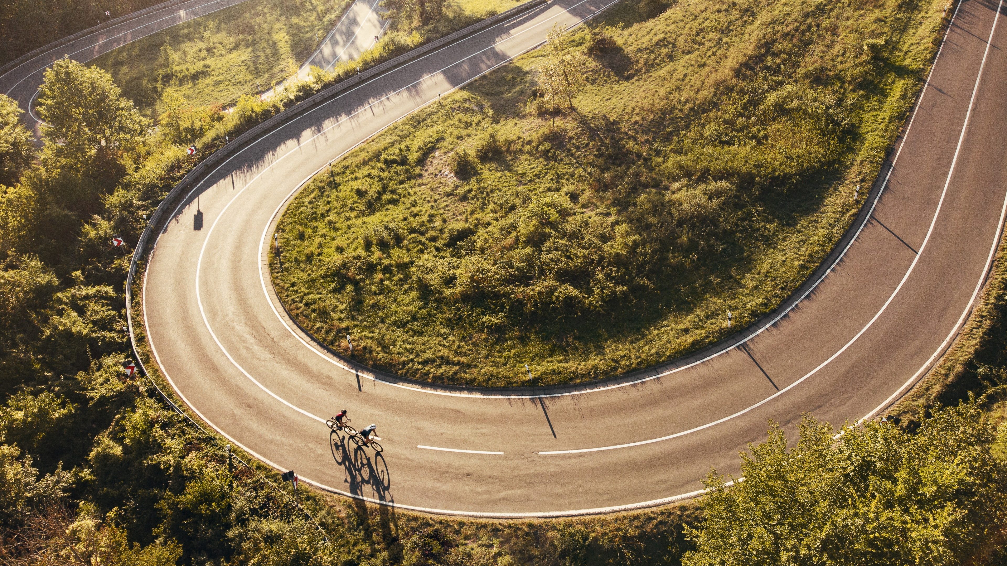 Aerial view on two cyclists on a windy mountainroad in upper franconia at sunset