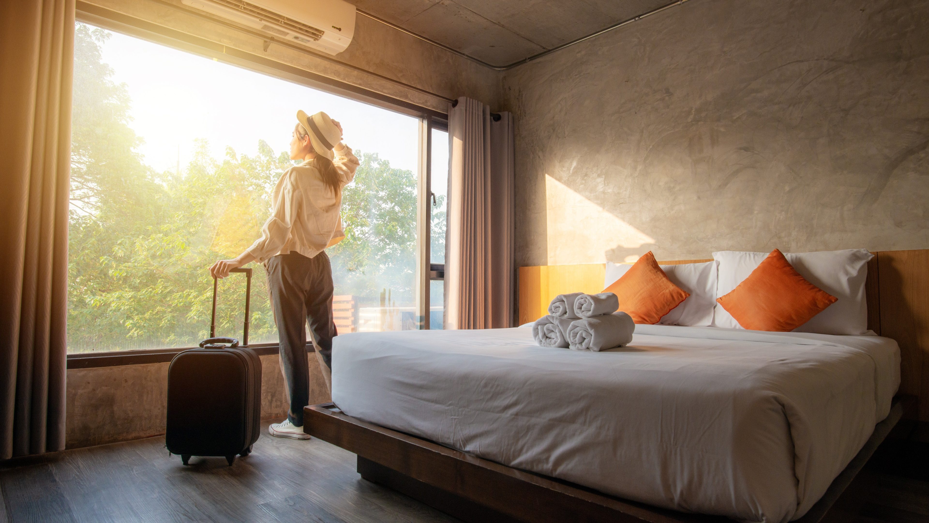 Tourist woman with her luggage in hotel bedroom.